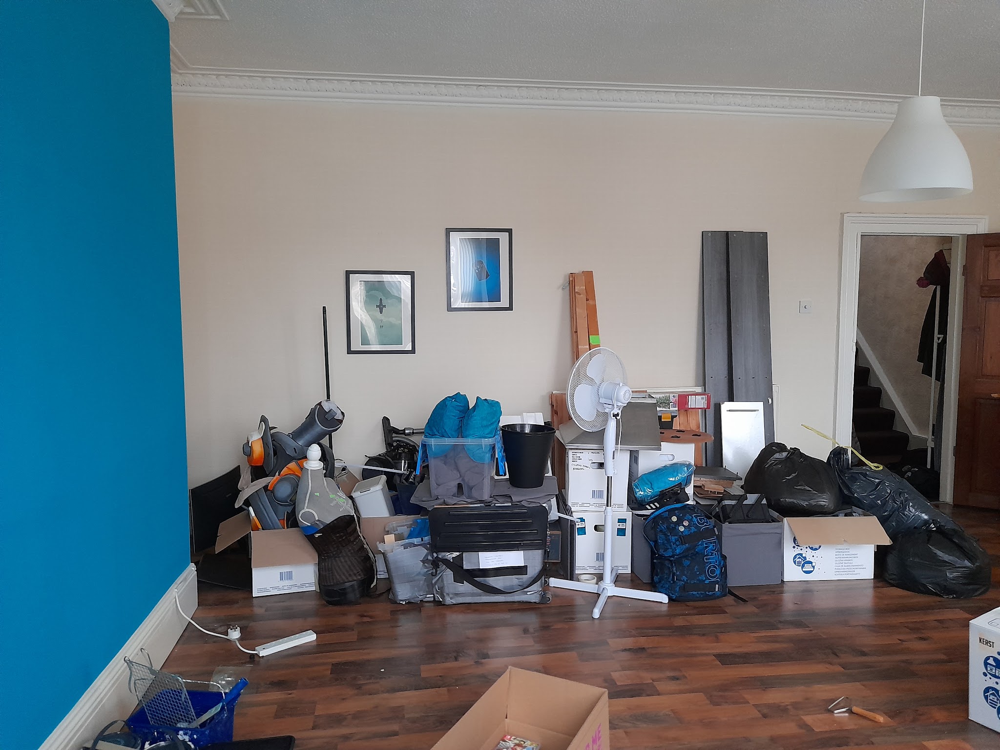 A living room with boxes, bags and belongings gathered for removal